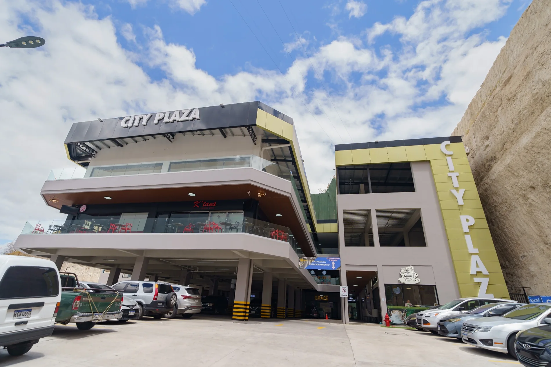 Vista real de la fachada y estacionamiento de City Plaza